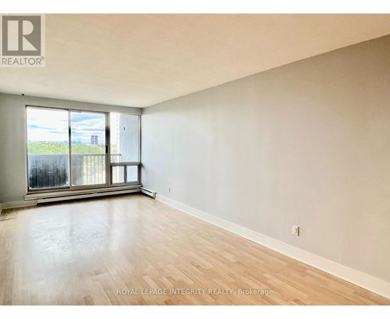 A room with a large window and wooden flooring.