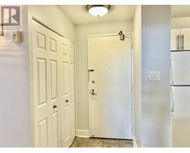 A white door with a black handle is in the middle of a hallway.
