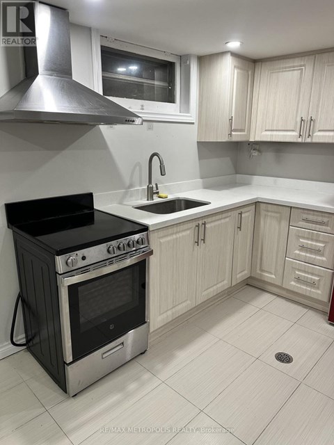A kitchen with a black stove and white cabinets.