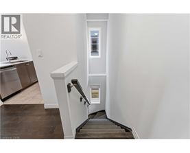 A staircase with a white railing and a window in the distance.