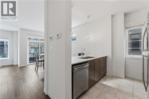A modern kitchen with stainless steel appliances and a dining area with a table and chairs.
