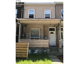A house with a white door and a wooden bench in front.