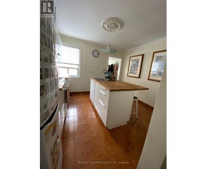 A kitchen with brown tile floors and white cabinets.