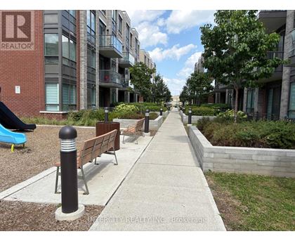 A walkway between two buildings with a sign that says "Invercity Realty Inc Brokerage".
