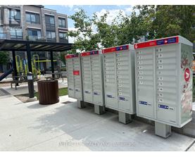 A row of mailboxes are lined up on a sidewalk.