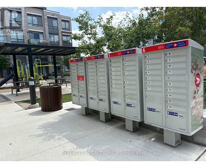 A row of mailboxes are lined up on a sidewalk.
