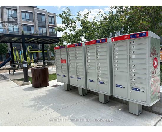 A row of mailboxes are lined up on a sidewalk.