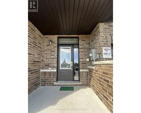 The entrance to a building with a glass door and a brick wall.