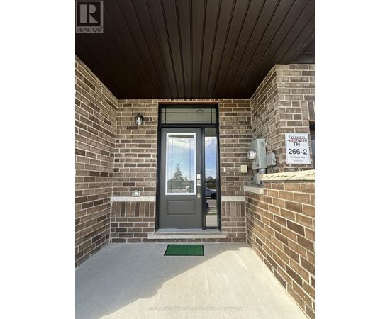 The entrance to a building with a glass door and a brick wall.