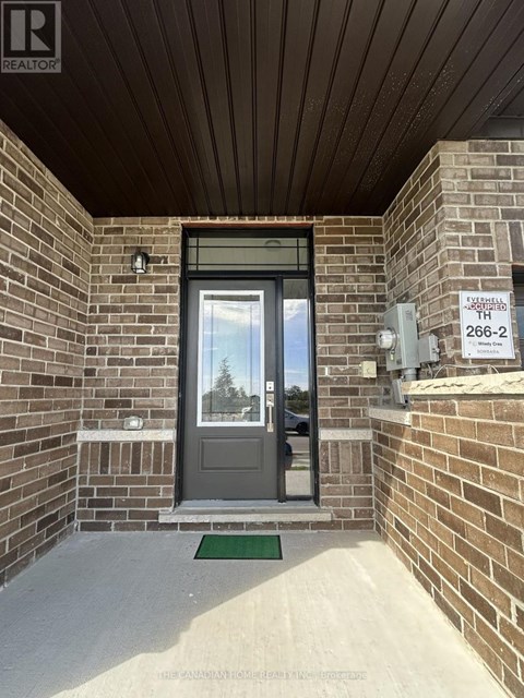 The entrance to a building with a glass door and a brick wall.