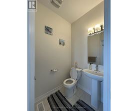 A white toilet and sink in a small bathroom.