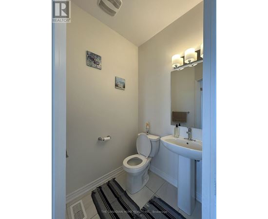 A white toilet and sink in a small bathroom.