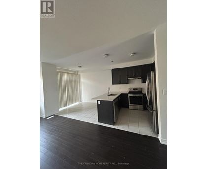 A kitchen with black cabinets and a white fridge.