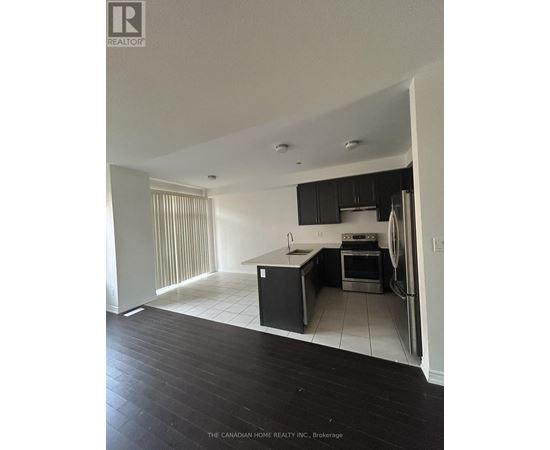 A kitchen with black cabinets and a white fridge.