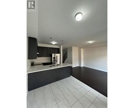 A modern kitchen with black cabinets and white countertops.