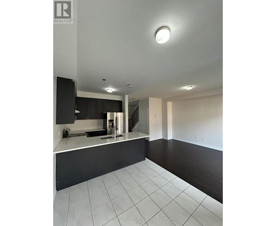 A modern kitchen with black cabinets and white countertops.