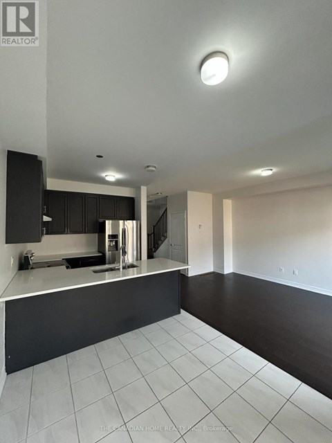 A modern kitchen with black cabinets and white countertops.