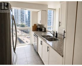 A kitchen with white cabinets and a stainless steel refrigerator.