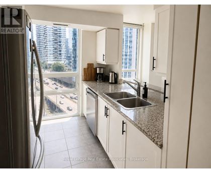 A kitchen with white cabinets and a stainless steel refrigerator.