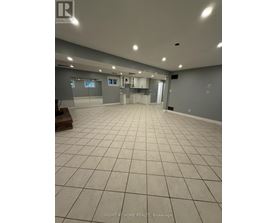 A spacious room with tile flooring and grey walls.