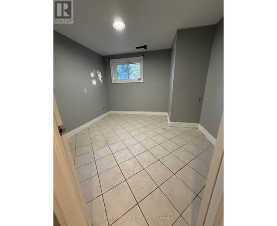 A room with tile flooring and a window.
