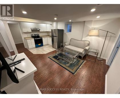 A kitchen with white cabinets and a wooden floor.