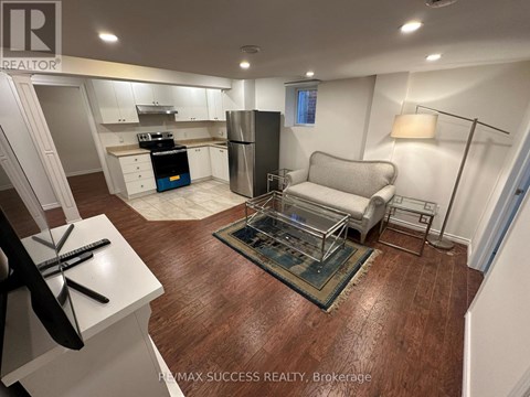 A kitchen with white cabinets and a wooden floor.