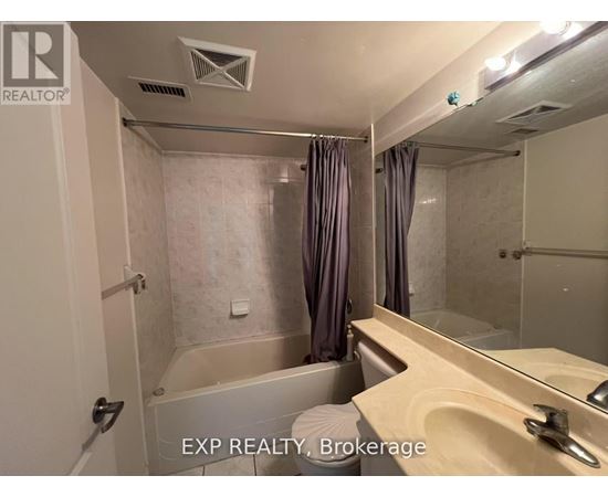 A bathroom with a tub, sink, and mirror.