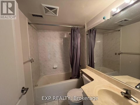 A bathroom with a tub, sink, and mirror.