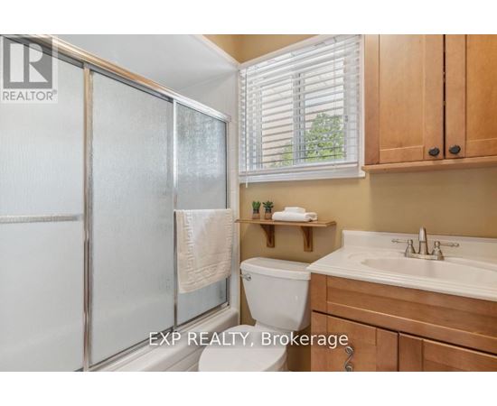 A bathroom with a toilet, sink, and frosted glass shower door.