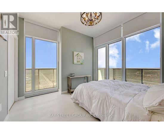 A bedroom with a large bed and a view of the beach.