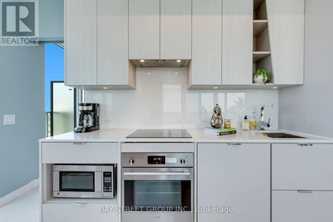 A modern kitchen with a microwave and oven built into the counter.