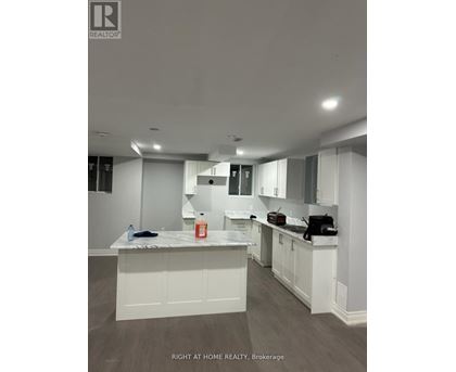A kitchen with white cabinets and a marble countertop.