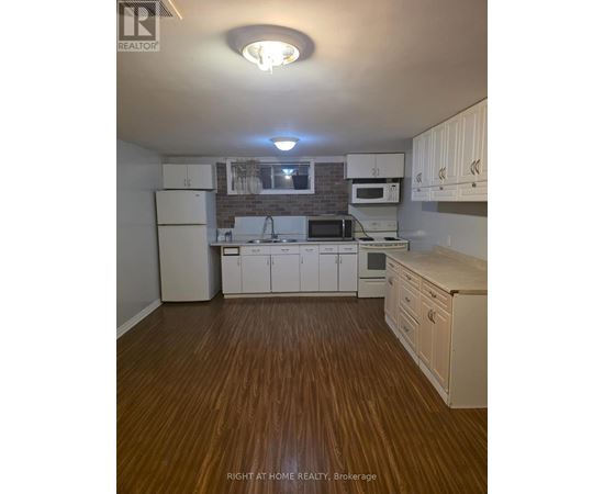 A kitchen with white cabinets and a brick backsplash.