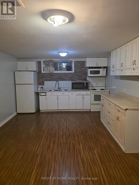 A kitchen with white cabinets and a brick backsplash.