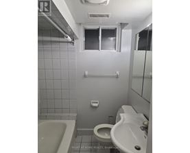 A bathroom with a toilet, sink, and bathtub.