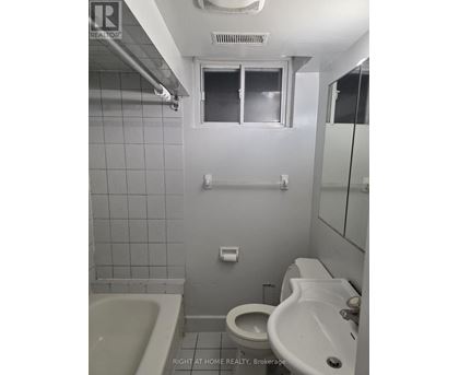 A bathroom with a toilet, sink, and bathtub.