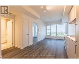 A spacious room with wooden flooring and white walls.