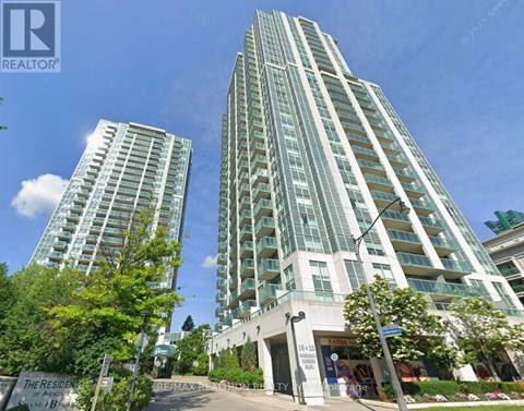 A tall residential building with a sign that says "The Resident".