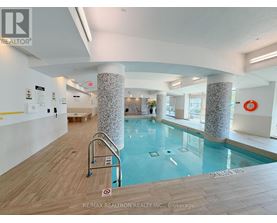 A pool inside a building with a sign that says RE/MAX REALTRON REALTY INC., Brokerage.