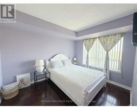 A bedroom with a bed, nightstand, and window.