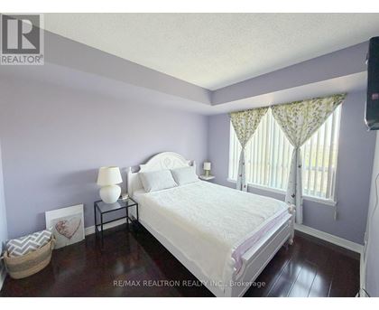 A bedroom with a bed, nightstand, and window.