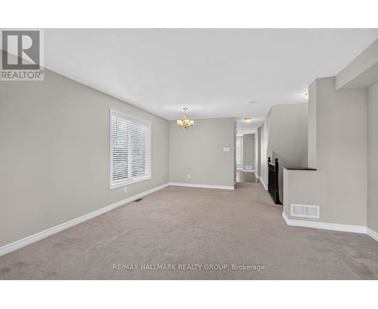 A spacious room with a window and a chandelier.