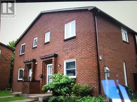 A red brick house with a blue tarp on the right side.