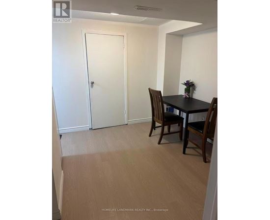 A room with a table and chairs and a door.