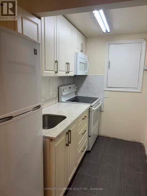 A kitchen with white appliances and cabinets.