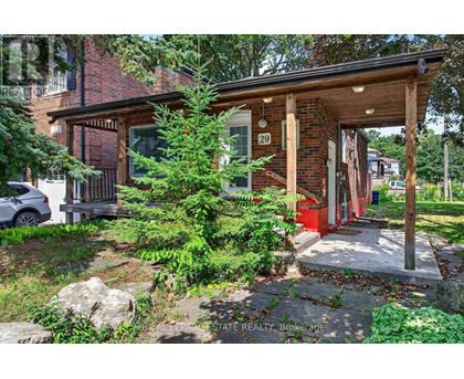 A house numbered 29 with a red door is surrounded by greenery.