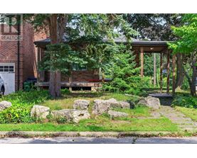 A house with a porch surrounded by rocks and trees.