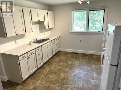 A kitchen with white cabinets and a tiled floor.