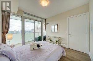 A bedroom with a large bed and a window overlooking a balcony.